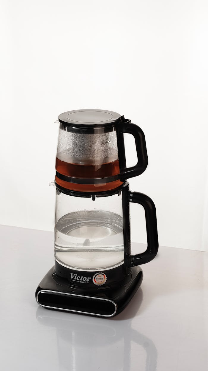 Home Sleek glass electric kettle with tea infuser, showcasing modern design and function.